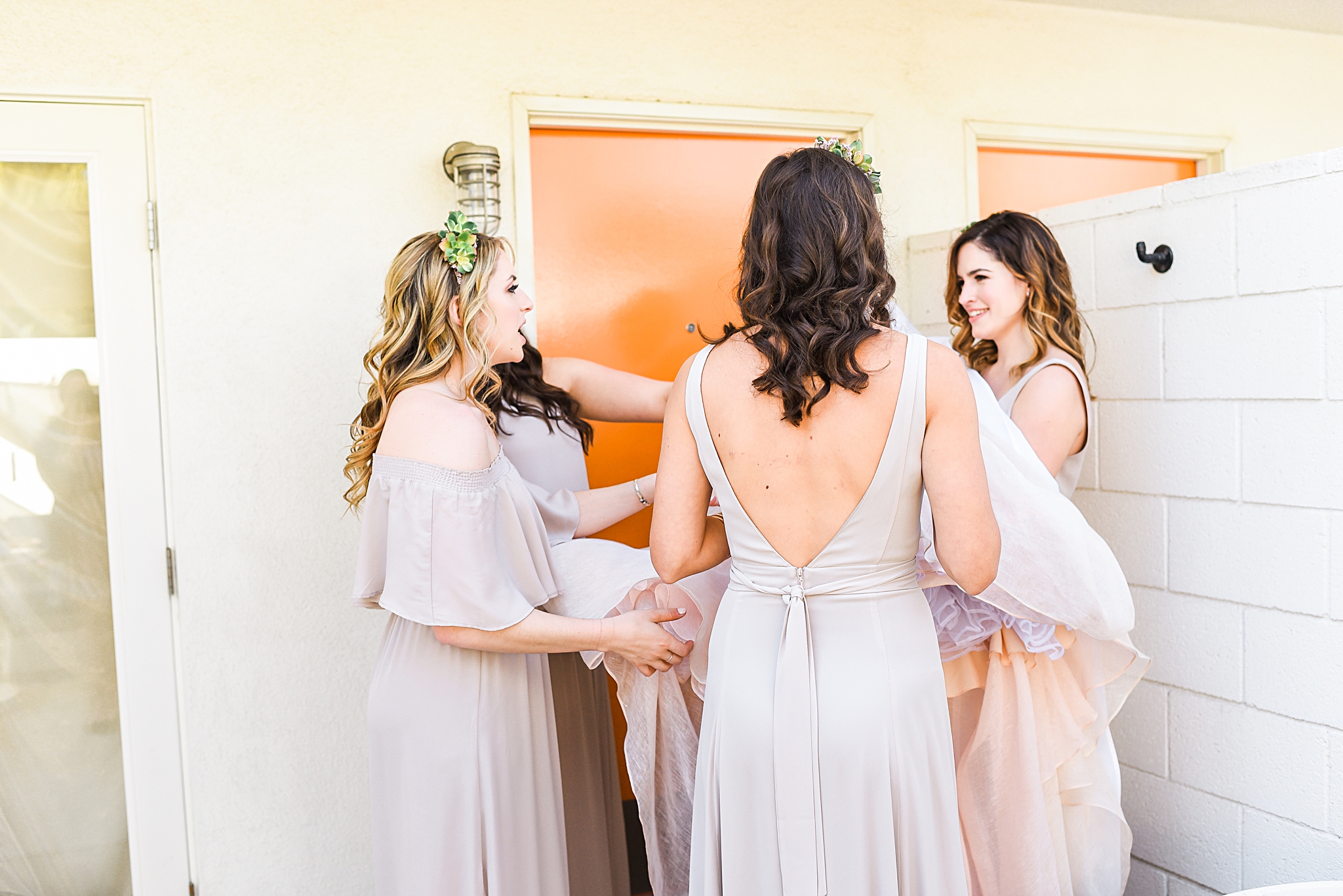 bridesmaids prepping the dress for the bride