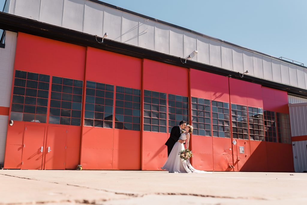 wedding couple in front of hangar doors
