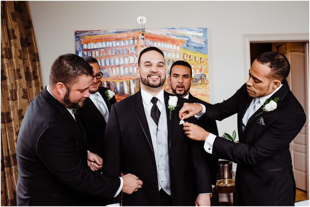 groomsmen helping groom get ready