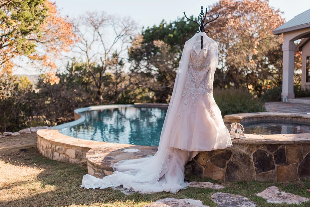 wedding dress hanging up by the pool