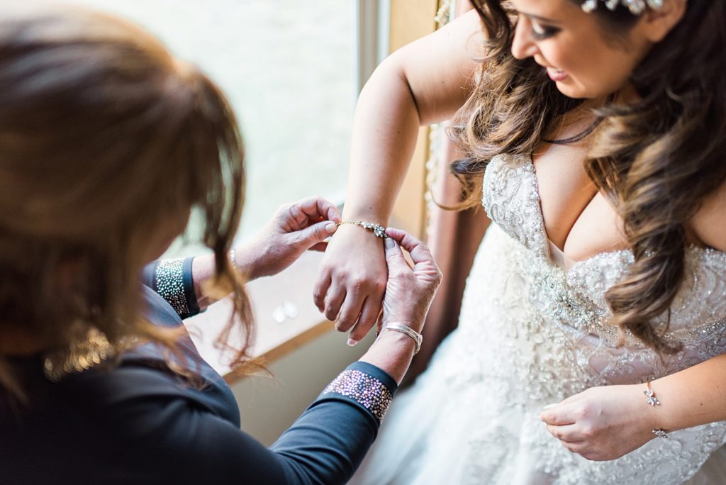 mother helping daughter get ready for wedding