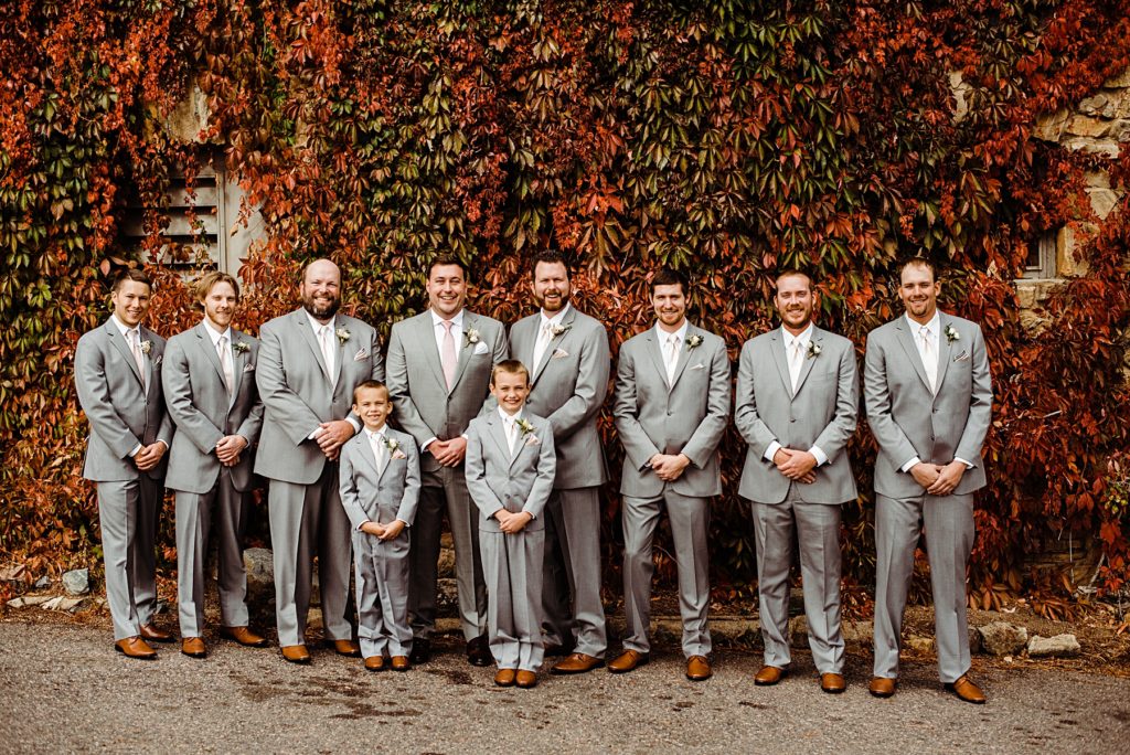 groom party in front of fall colored wall