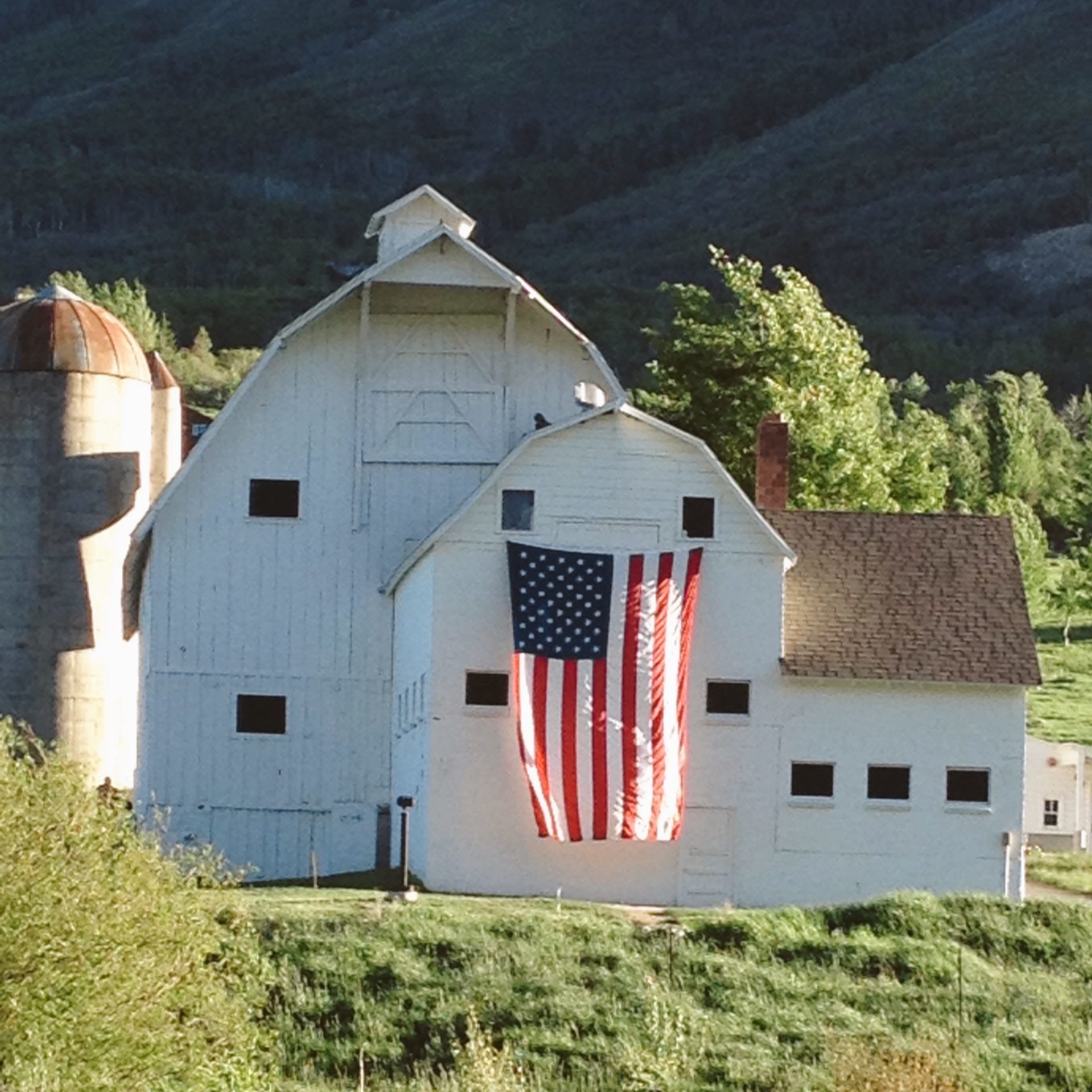 We the People of the United States flag on a white barn