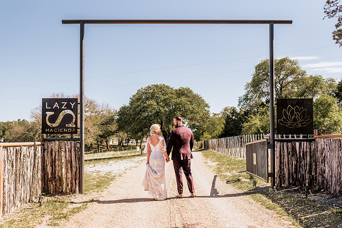 bride and groom walking down a dirt path at a texas ranch wedding