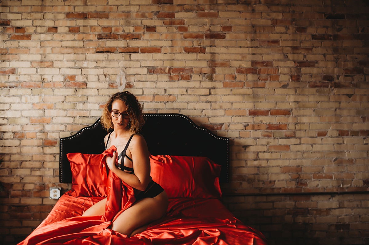 boudoir with red satin sheets milwaukee boudoir photographer ashley durham photography the secret pinup