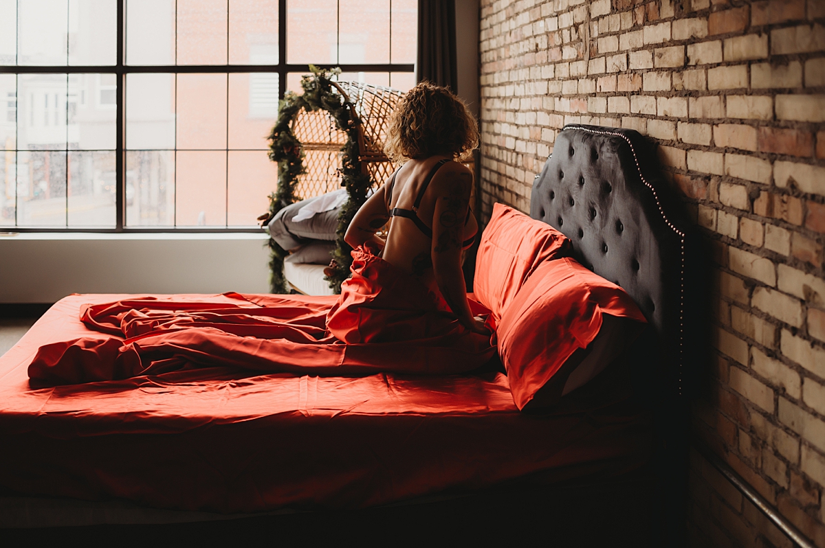 boudoir with red satin sheets milwaukee boudoir photographer ashley durham photography the secret pinup