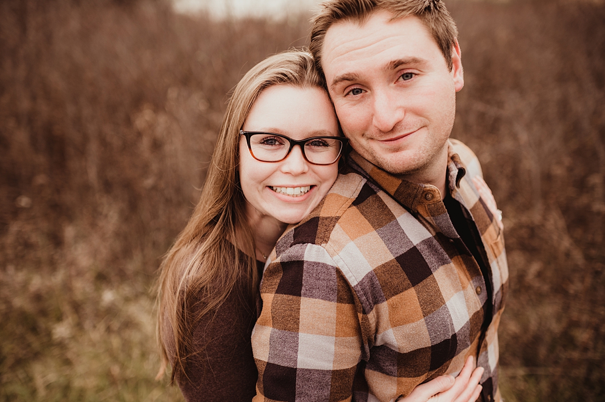 engagement session pose with woman hugging fiance from behind