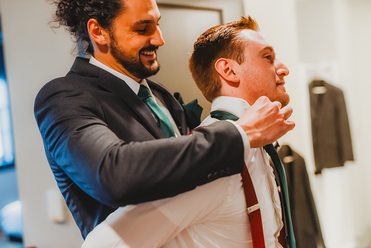 groomsmen helping groom get ready for kenosha wedding
