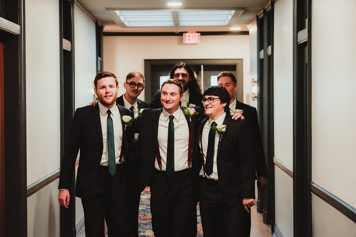 groomsmen helping groom get ready for kenosha wedding