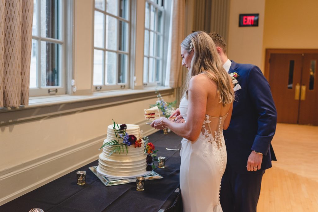bride and groom cutting wedding cake at wedding reception
