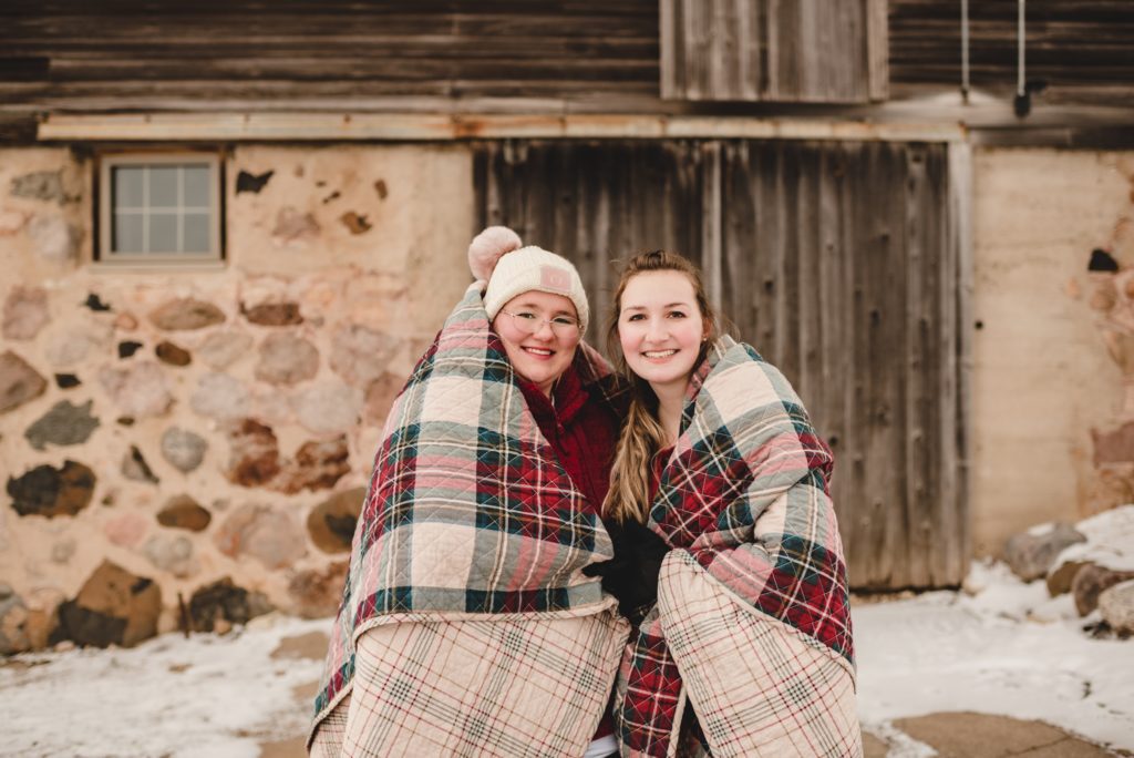 two adult women wrapped in a blanket for family session in the winter