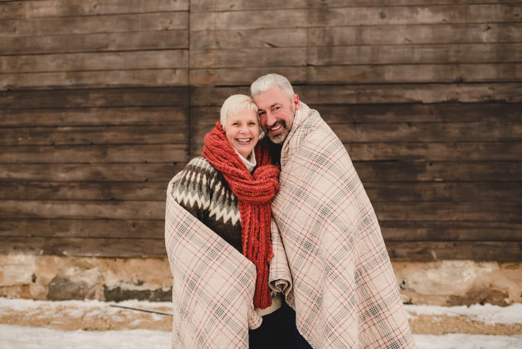 couple wrapped in plaid quilt for winter photo session
