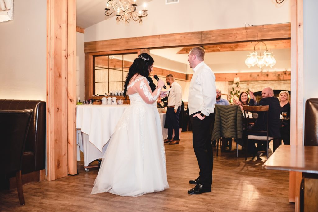 bride and groom giving toast at indoor wedding reception