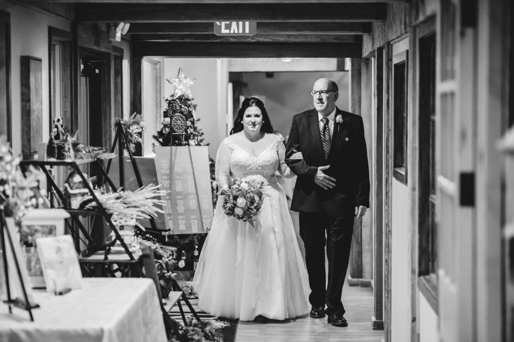 black and white image of father escorting bride to wedding ceremony