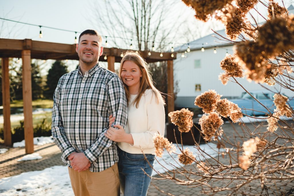 woman standing behind man during engagement session