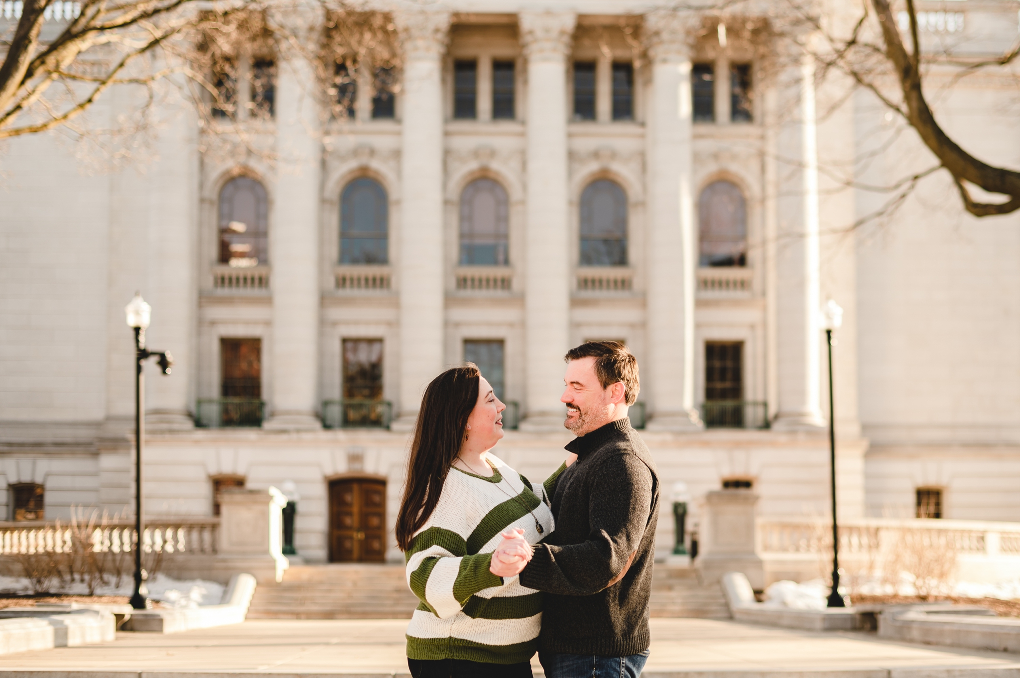 engaged couple dancing in front of the capitol building in wisconsin