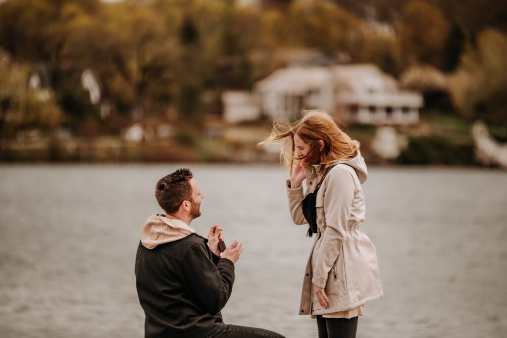 man showing woman ring in ring box at surprise proposal