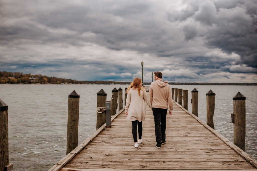 couple walking away from camera on a boat deck on a stormy day