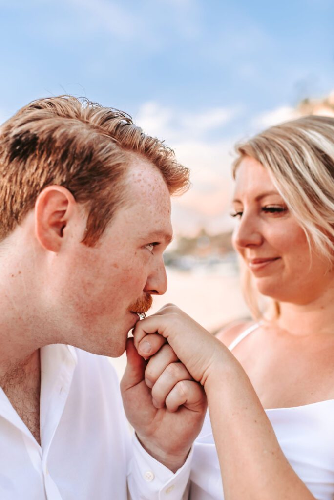 engaged man kissing the hand of his new fiance
