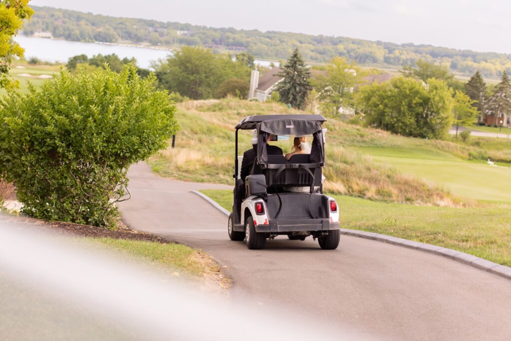 bride and groom riding a golf cart