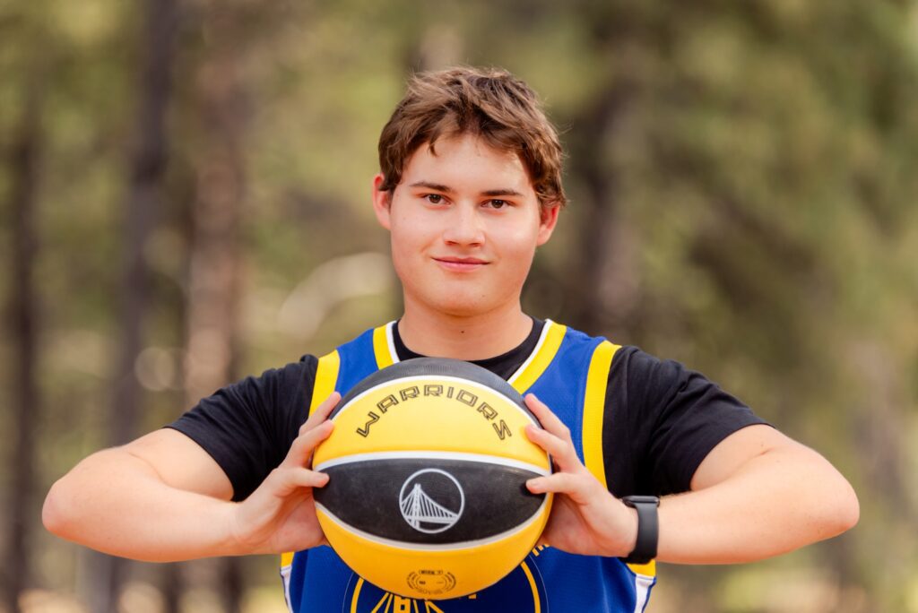 senior boy wearing warriors basketball jersey