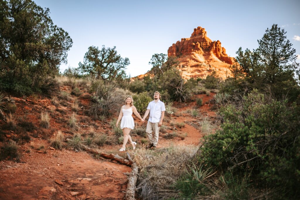 woman holding hands with man walking together in the sedona desert