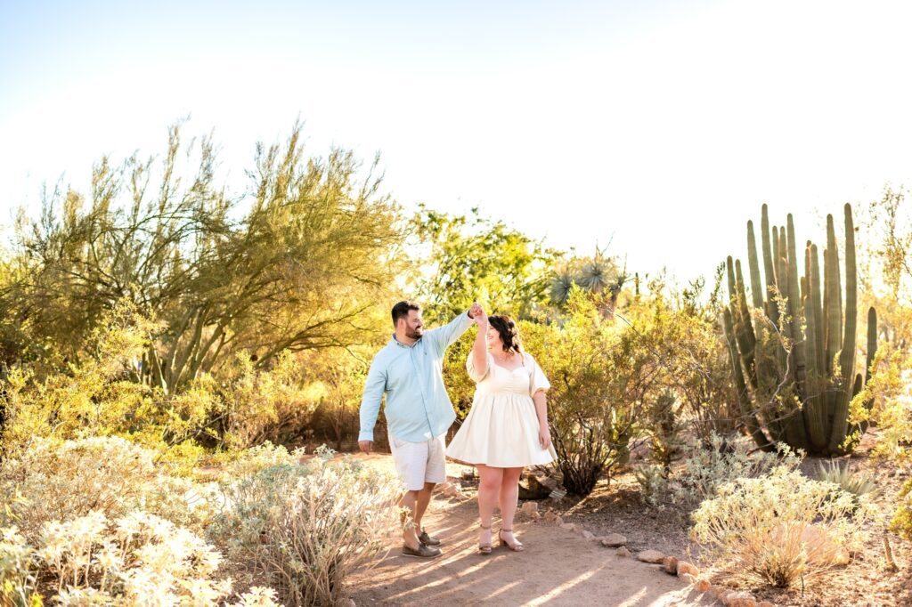 engaged couple dancing together in the desert botanical garden