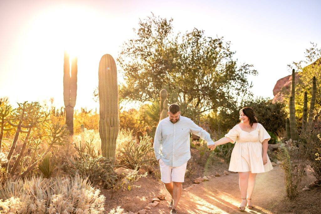 couple walking together in a cactus garden for phoenix engagement photos