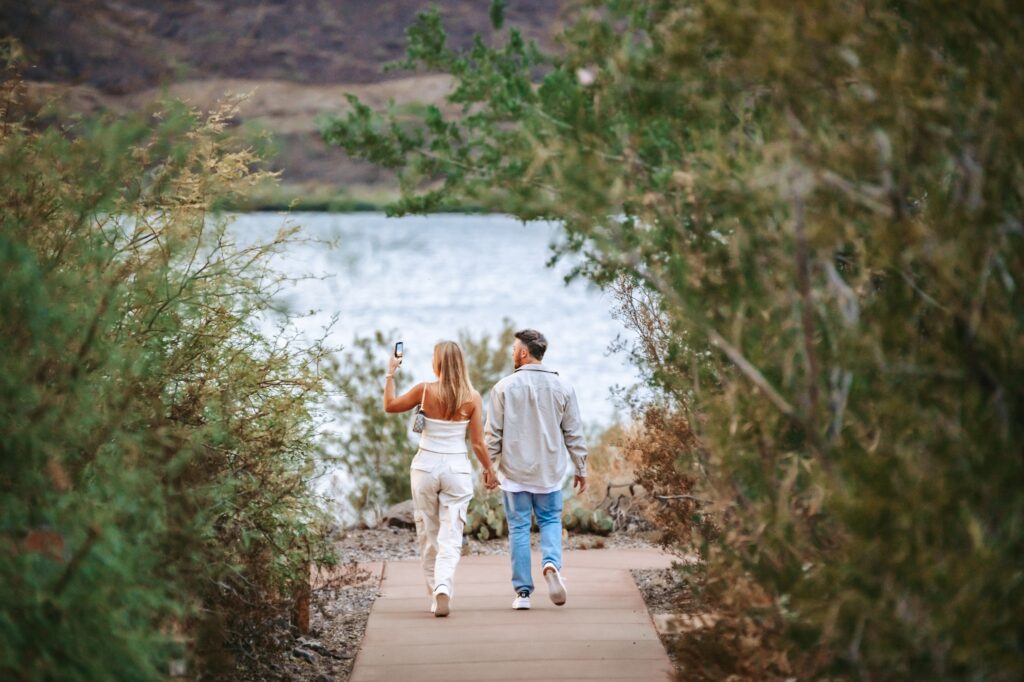 couple walking together hand in hand by the lake