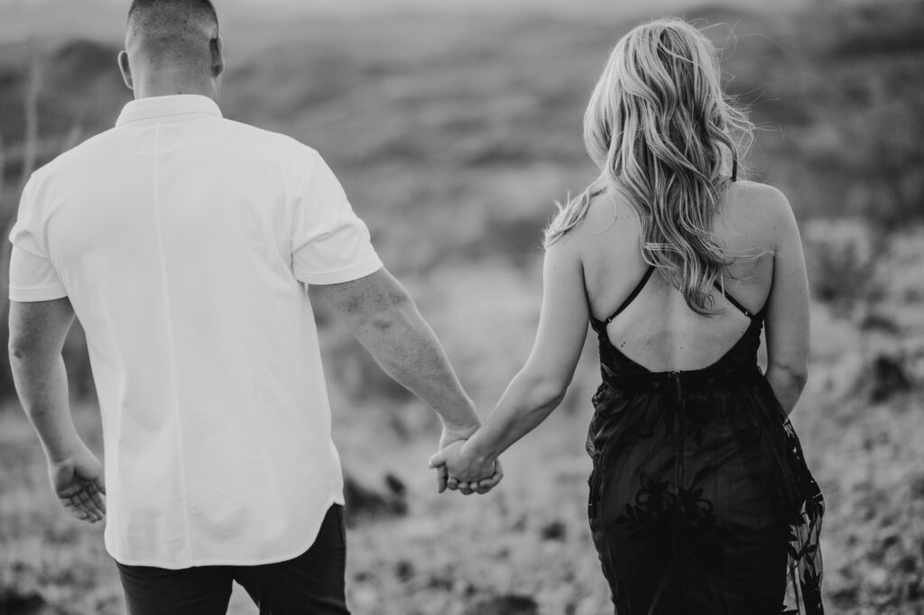 black and white photo of couple walking together away from the camera