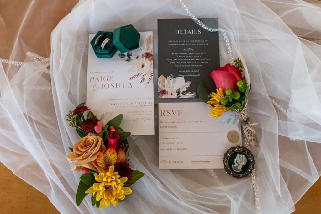 wedding invitiation suite flat lay with veil and flowers