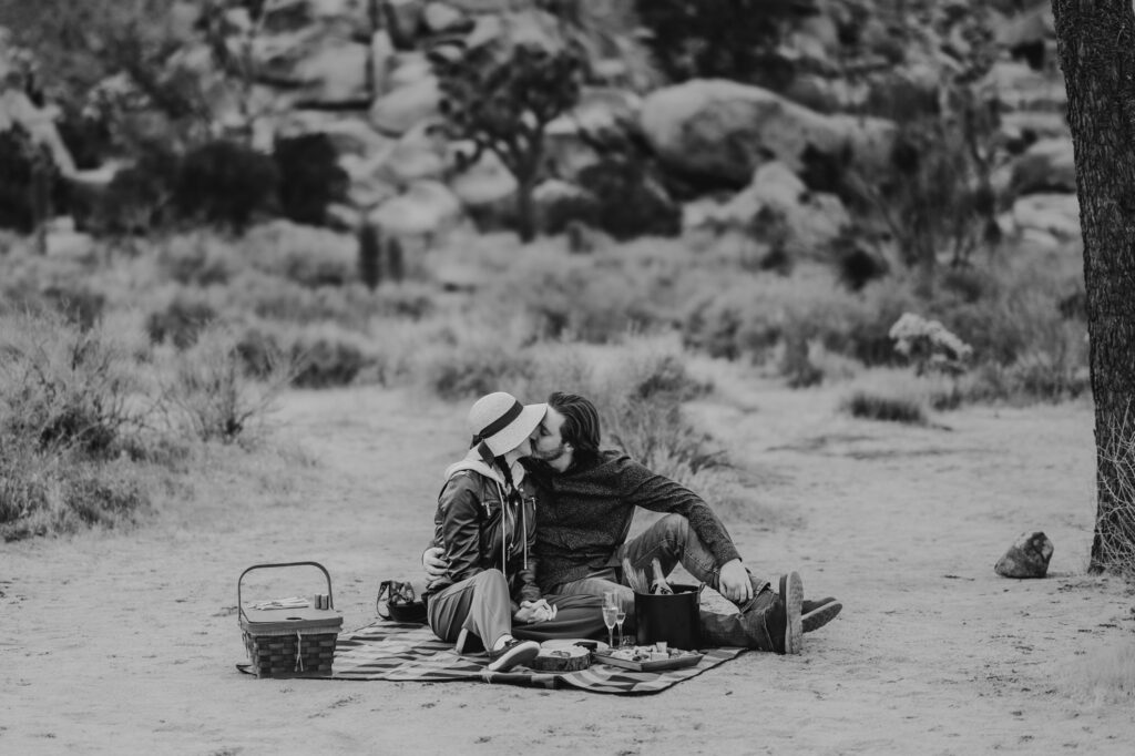 man kissing at engagement picnic