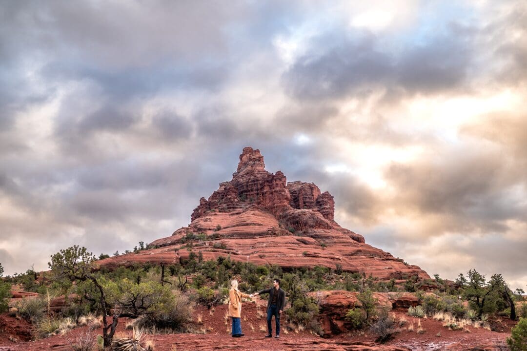 engaged couple dancing together in front of bell rock