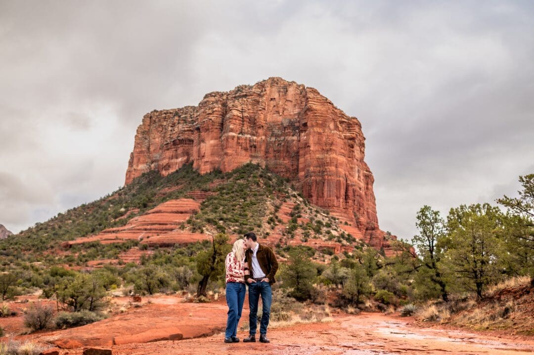 couple walking together in front of courthouse butte in sedona