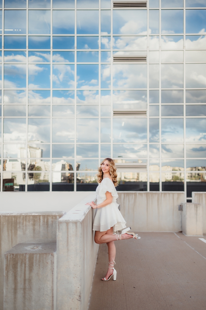 senior girl next to building with clouds reflecting