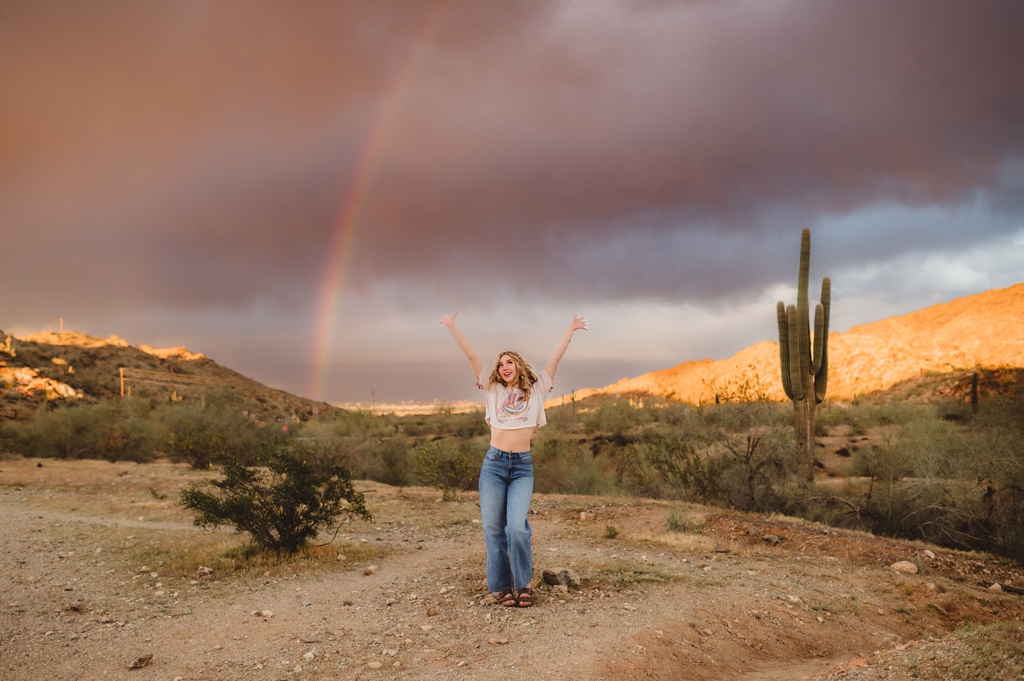 senior portraits with a rainbow in the background