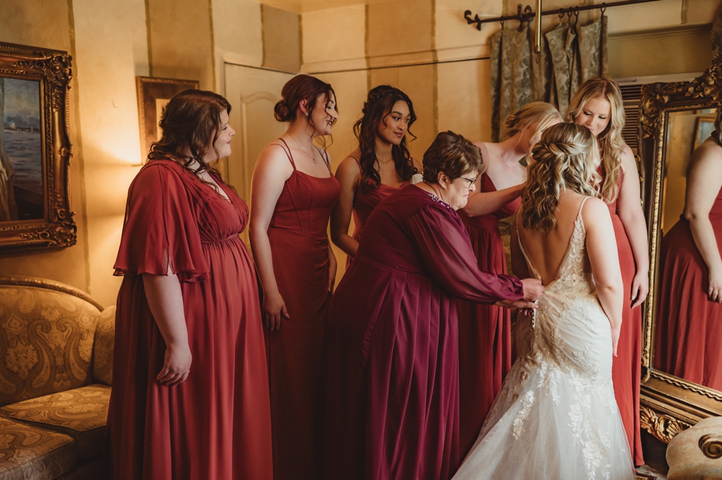 bride getting ready surrounded by bridesmaids