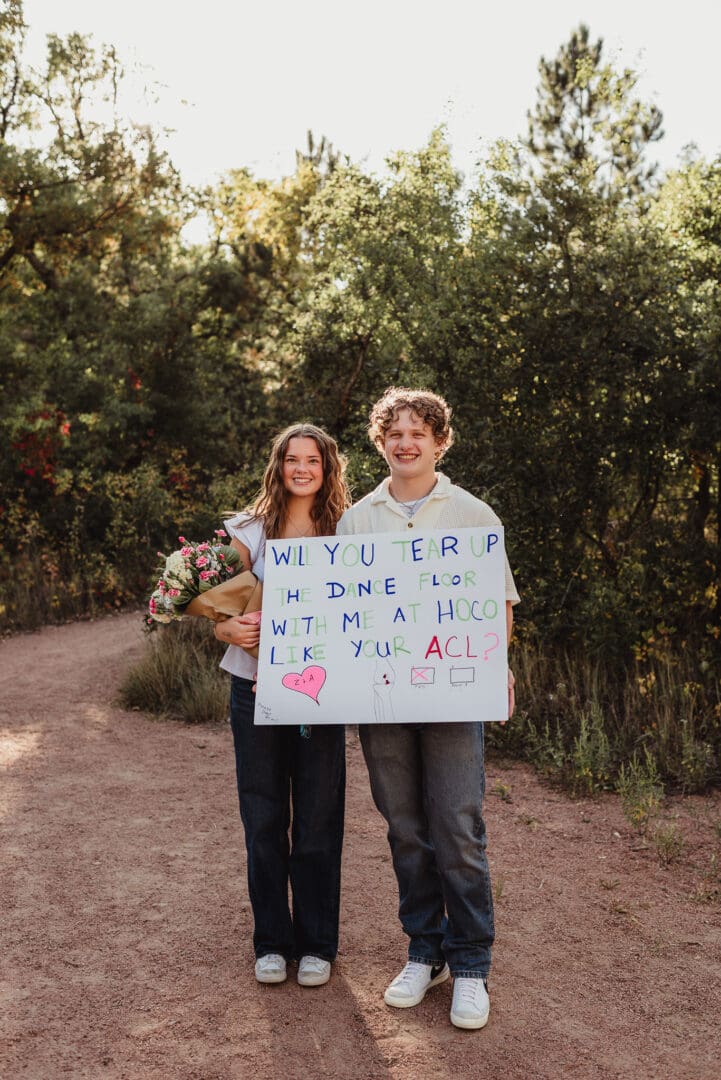 senior couples hoco proposal with a sign