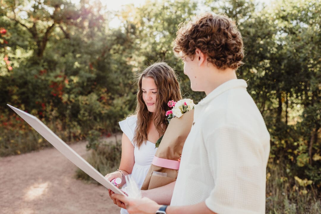 senior couples hoco proposal with a sign