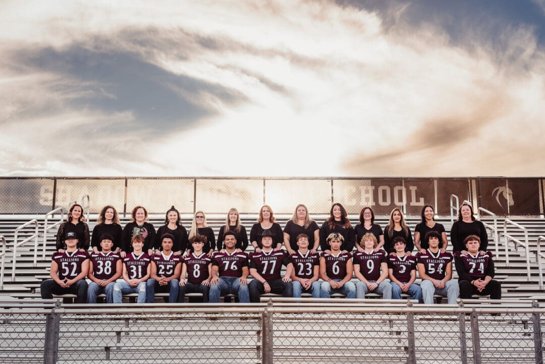group photo for senior football moms in the stadium