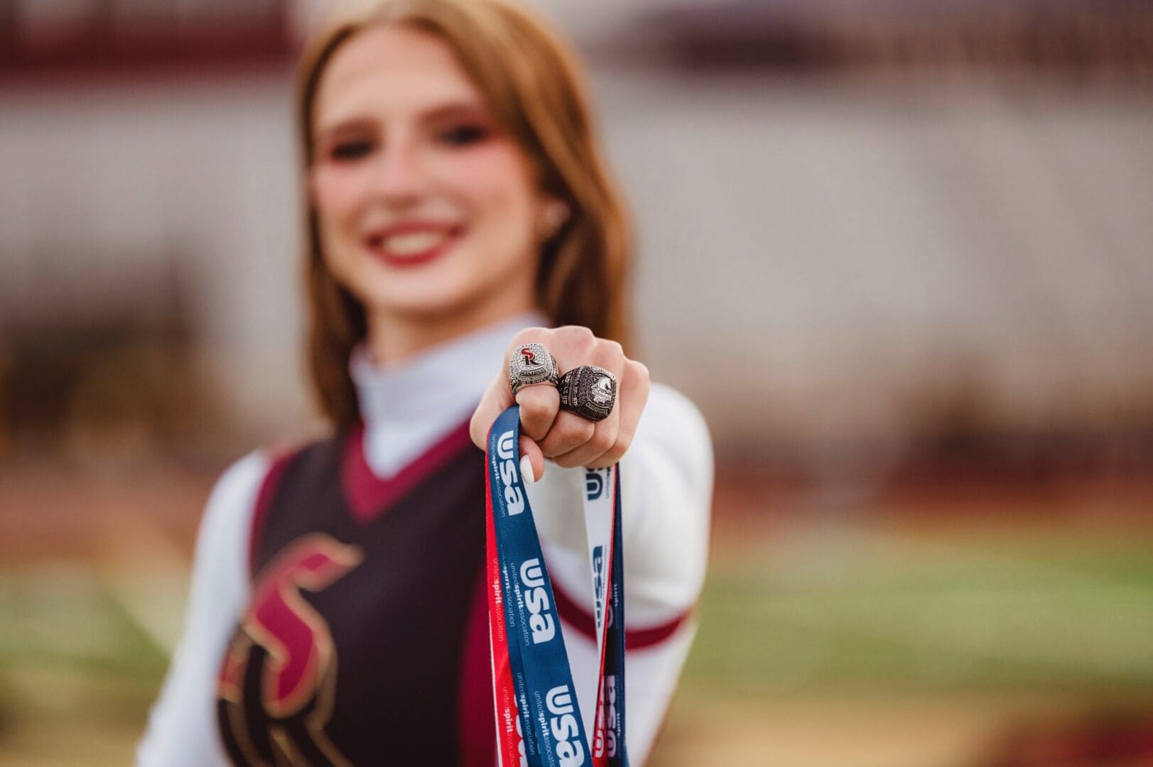 senior athlete showing off championship rings and medals