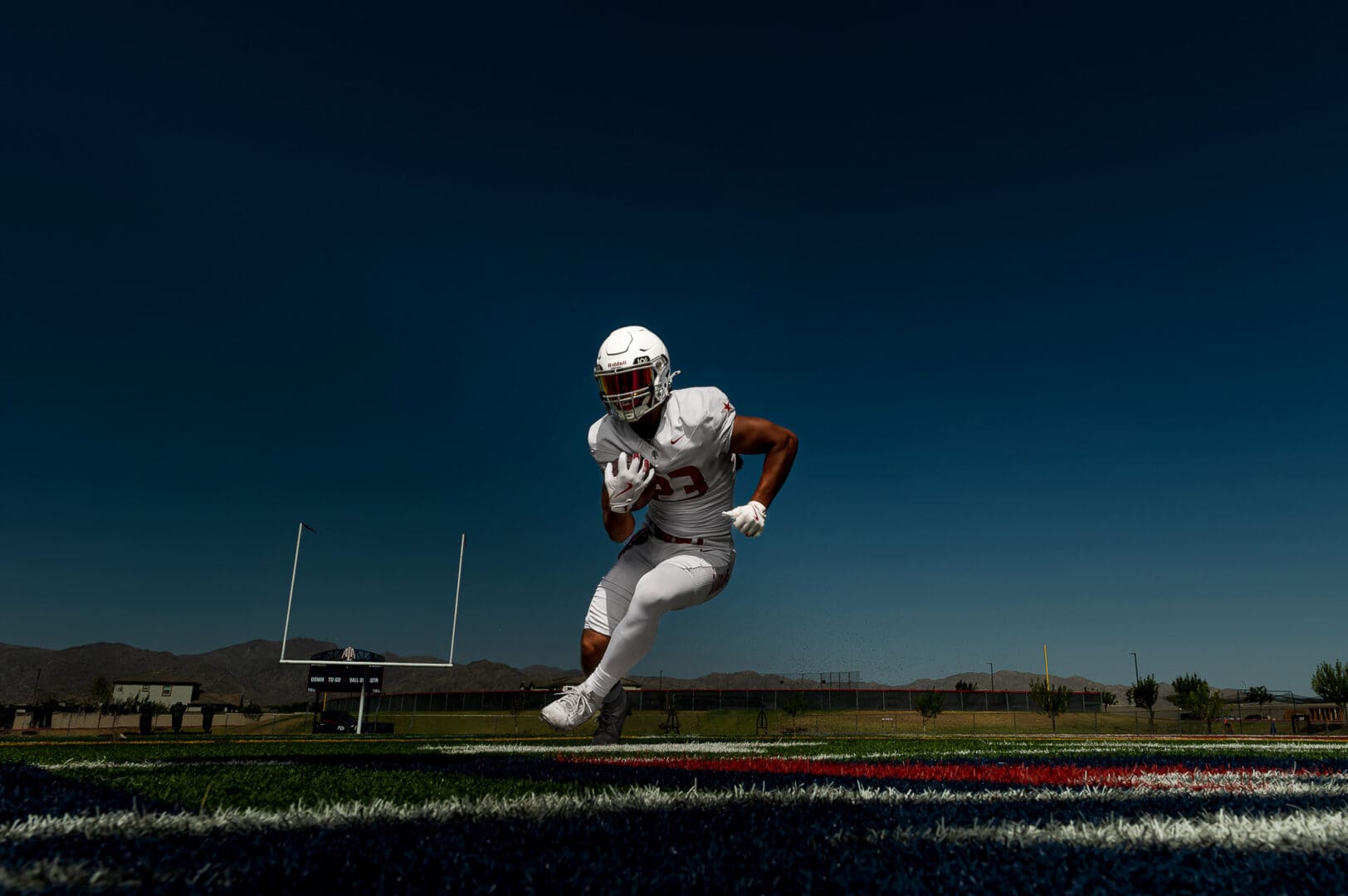 runningback poses for sport portraits on the football field 