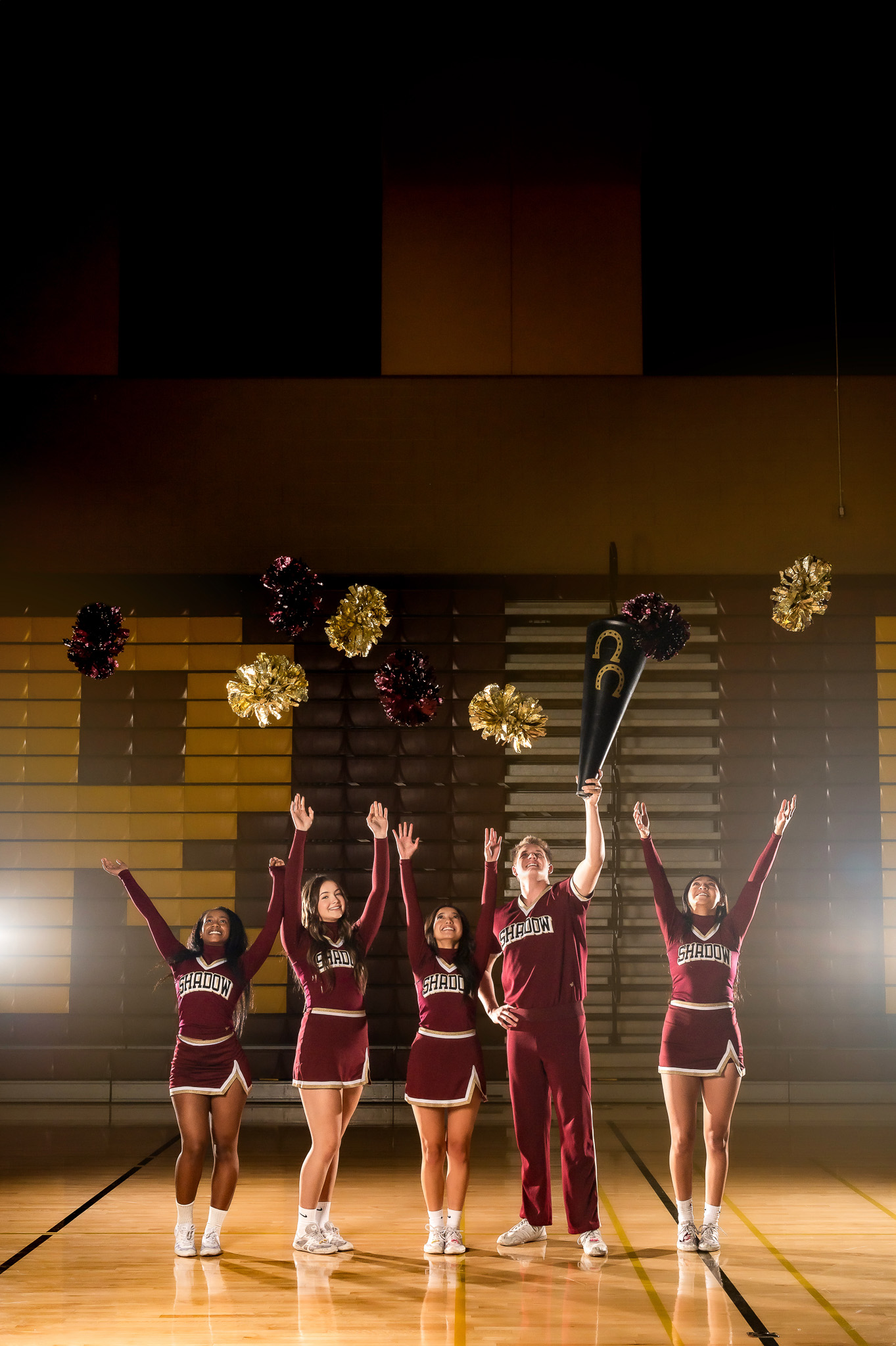 cheerleaders tossing poms up in the air