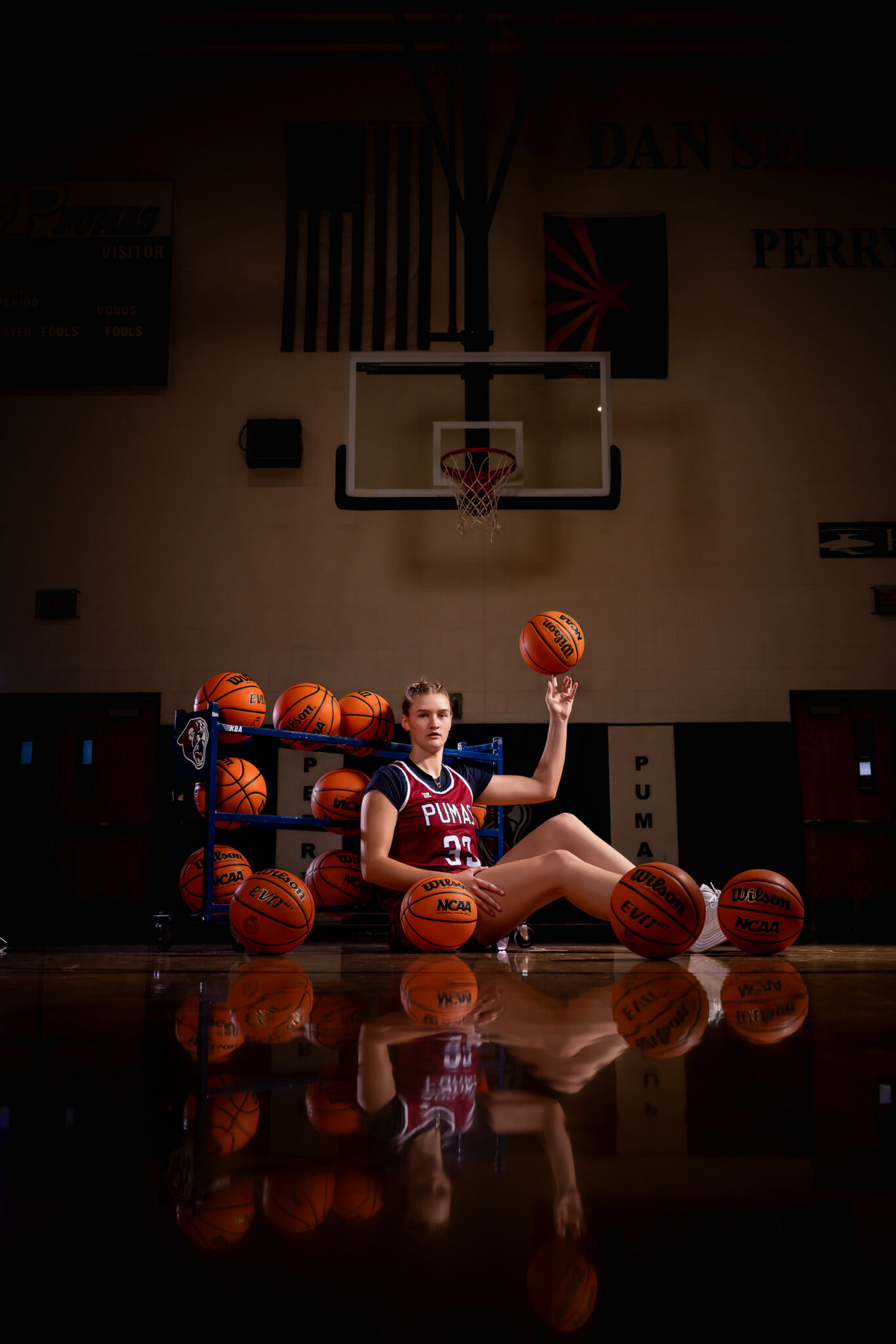 High school girls basketball player posing on the hardwood court during senior photos