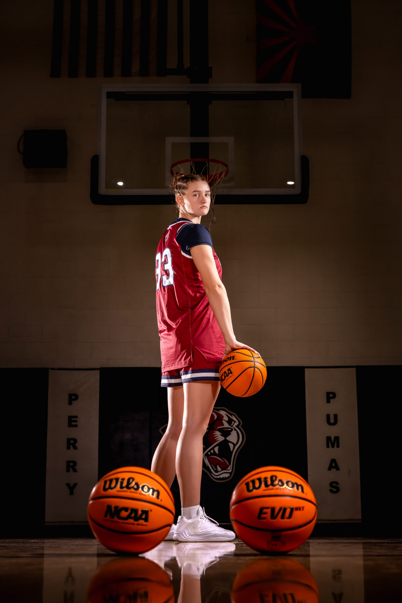 Female basketball player standing confidently on her high school basketball court in Gilbert, Arizona