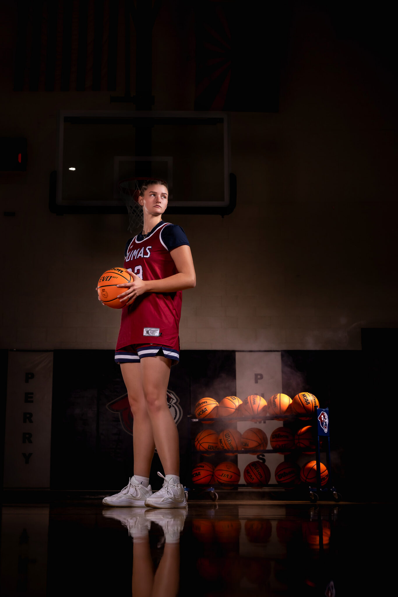 High school senior athlete holding a basketball during her sports portrait session in Gilbert